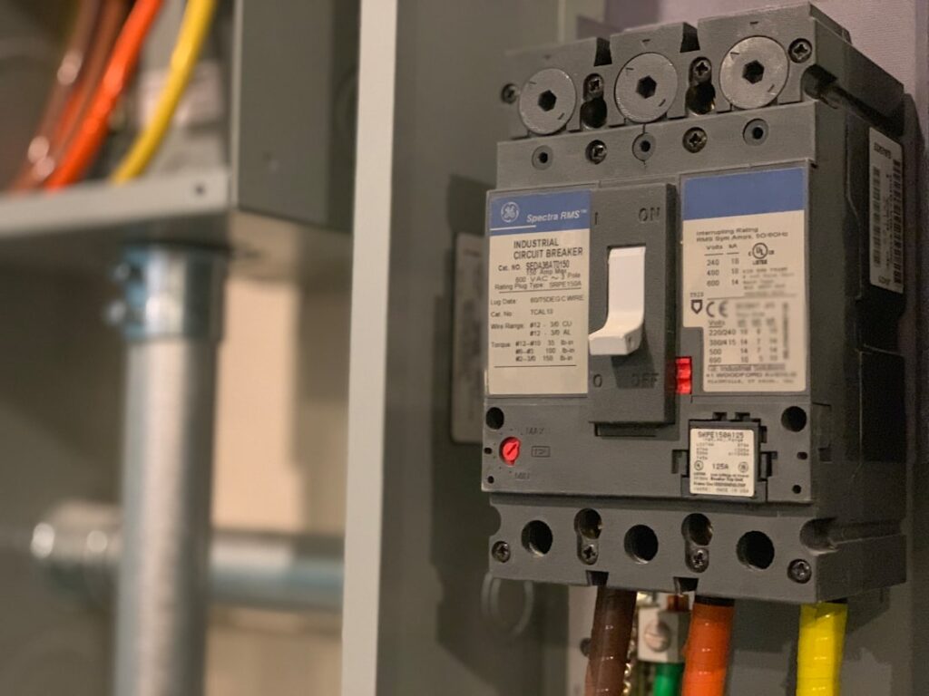 Molded case industrial circuit breaker installed in electrical panel with terminal wiring — marine-type approval adds environmental testing requirements beyond IEC 60947-2