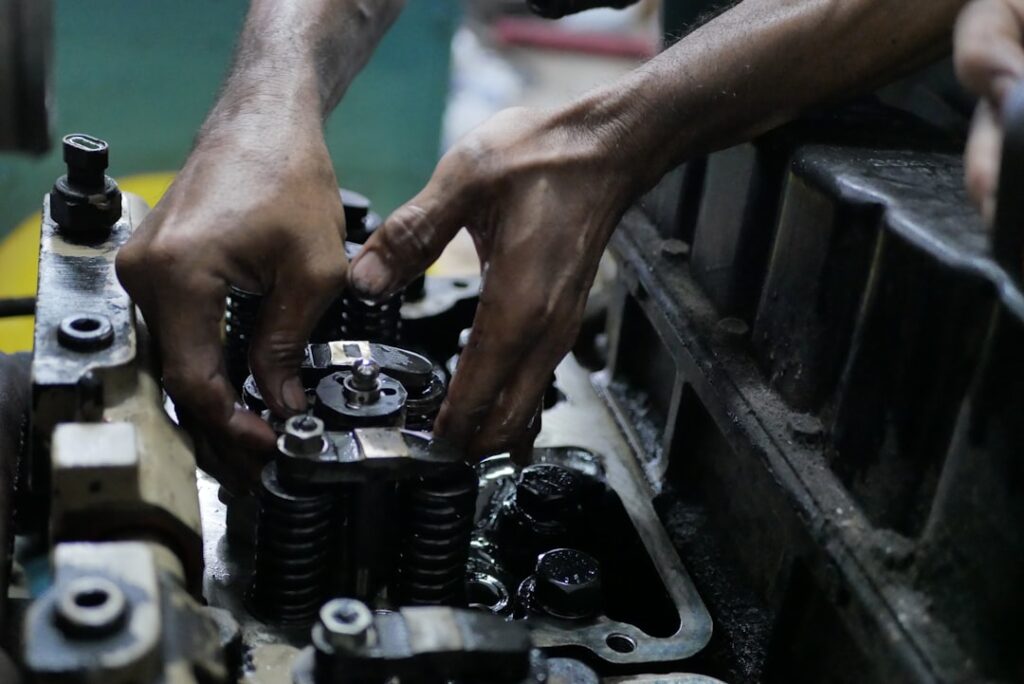 Marine engineer's hands working on cylinder head components during engine overhaul