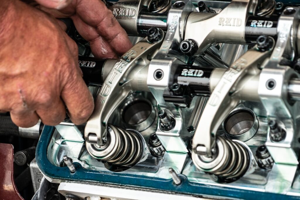 Technician's hands working on precision engine valve components, illustrating the importance of genuine OEM parts for critical rotating assemblies