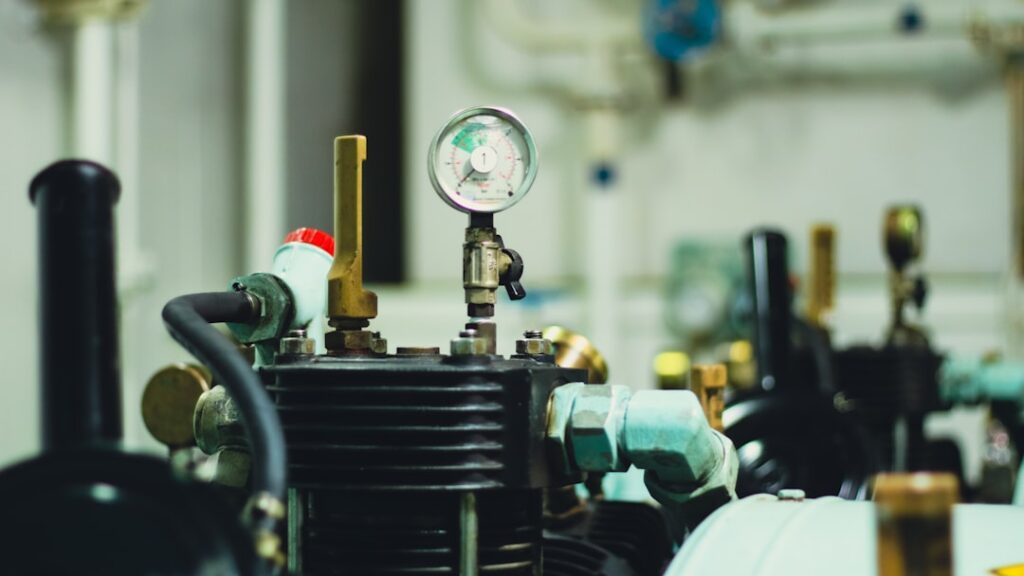 Marine vessel engine room showing air compressor machinery, pressure gauges, and piping typical of commercial ship mechanical systems