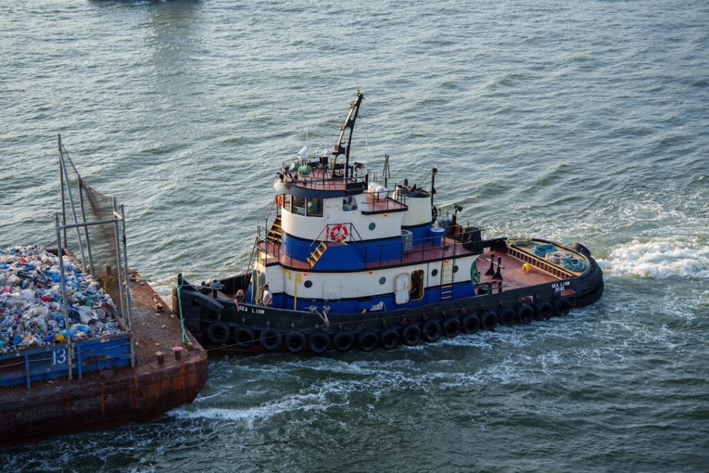 A harbor tugboat pushing a loaded barge on open water, representing Gulf commercial workboat and tug operations that rely on Yanmar auxiliary engines